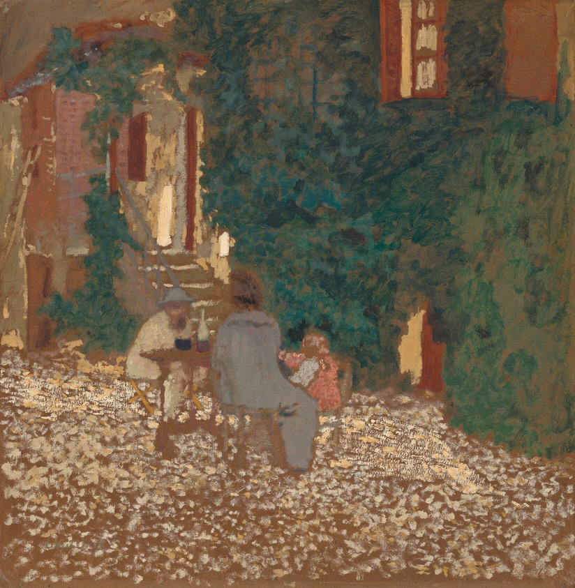 Two people, perhaps a woman and man, and a baby sit at a table in a courtyard surrounded by vine-covered walls in this square painting. The scene is loosely painted with visible dabs, dashes, or smudges. The table is to the left of center. The man sits on the far side, to our left, and the woman, who appears to have her brown hair pulled up, sits facing away from us wearing a smoke-gray garment. A child wearing pink and pale blue sits to our right of the woman and seems to raise both arms. The ground is dotted with cream white and fog gray against the brown board on which this was painted. Steps lead up to a building at the back of the courtyard to the left, and the vine-covered wall stretches across the right two-thirds of the background. The artist signed the lower left corner, “E Vuilllard.”
