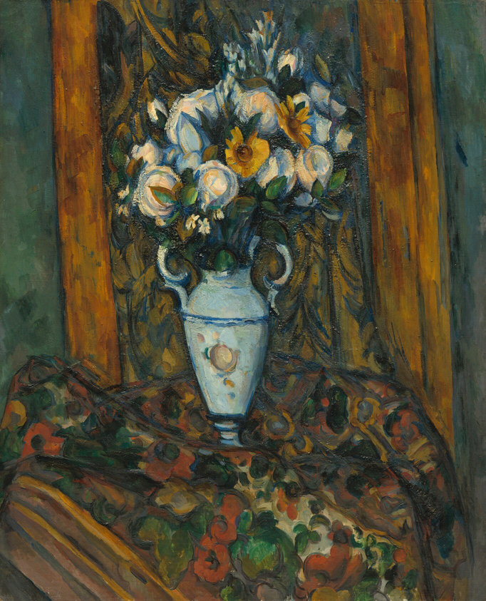 A vase holding mostly white flowers sits on a floral-patterned cloth in this vertical still life painting. The ice-blue vase has a narrow foot, tall, slightly tapering sides, round shoulders, and a long neck flanked by handles. An ivory-white circle at the center could be a flower painted on the body. The flowers the vase holds are all pearl and snow white except for two golden yellow flowers and dark greenery. The cloth on which the vase sits is patterned with muted red and dark yellow flowers with green leaves against parchment white and earth brown. A few brown lines cutting across the bottom left corner of the painting could be the edge of a wooden table. Just behind the flowers, a cloth or curtain patterned with dark yellow, moss green, and spruce blue hangs against a teal-green wall, visible along each side of the composition. The objects are loosely painted and outlined with cobalt blue.
