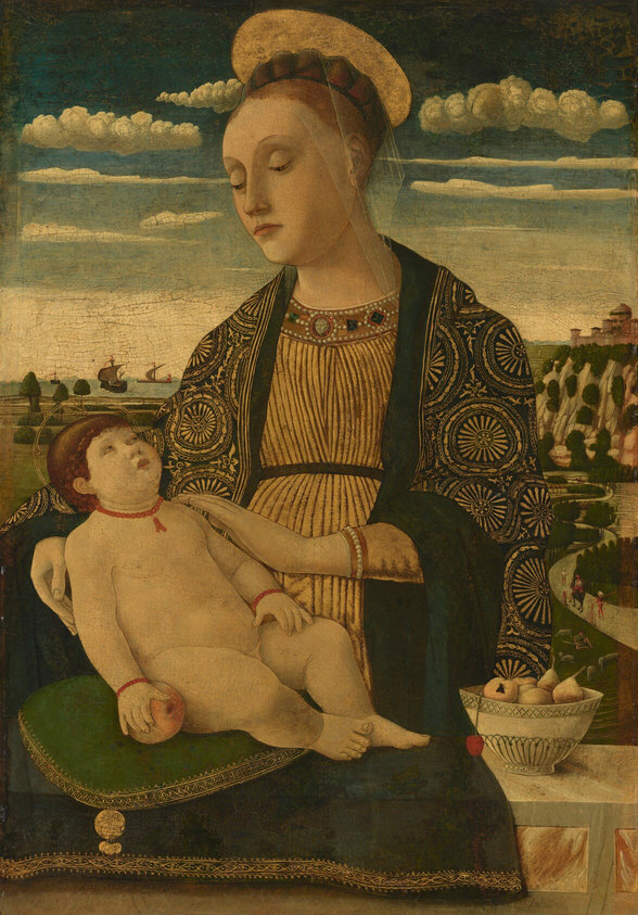 This painting depicts a woman holding a child. The woman is turned towards the left, and she looks down at the child in her lap. She has pale skin, reddish-brown hair, high, arched, eyebrows, and thin, slightly downturned lips. Her hair is put up above her head under a red and brown net with a thin veil hanging over her face. A golden halo is behind her head. Her clothes are ornate, in shades of gold and brown with a collar decorated with pearls and green gems. The child is nude except for a red necklace and red bracelets. They also have pale skin and brown hair, and they are looking up at the woman. The child rests on a green cushion and holds a light pink peach or apple in one hand, and there is a faint golden halo around their head. Next to the woman, on a white marbled surface, is a white bowl of light pink fruit. Behind her is a landscape of green fields, tree-lined, rocky hills, and a light blue body of water. The sky above is a gradient of blue, white towards the horizon and fading into dark blue at the top of the painting. Puffy white clouds drift across the top of the sky.