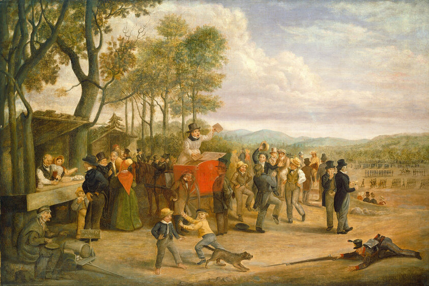 Approximately two dozen people gather around a man standing with his mouth wide open and holding up two objects in a scarlet-red structure on a horse-drawn cart in this horizontal painting. The people appear to all have pale skin and most are men. Near the center of the composition, the man in the cart wears a white robe over a black, high-collared garment and a tall charcoal-gray hat. A hatch on the red structure appears to be open, and he holds up what might be books or pamphlets. A ginger-brown horse stands behind him with its head bowed. In the crowd, the men wear black, brown, gray, dark blue, or olive-green clothing and hats. Two women are to the left. One wears a green gown with a pumpkin-orange shawl and a wide-brimmed bonnet. She faces away from us. She and two men talk near a stand where another man and woman sell food and drink. More people gather around a second stand or structure beyond this, and, in the lower left corner of the painting, a man with white hair and a hooked nose and chin sits by an open cart with a sign reading, “Bear O! Pi Aiggs.” A few men dance and others mill about to the right of the cart. Closer to us, one boy runs toward another as a soldier lies belly-down on the ground, holding a bayoneted rifle out toward a brown dog. The dog crouches with its mouth open. Beyond the dancers and onlookers, a field stretches back to wooded hills. In the field, more than a hundred people stand or march in lines. Lavender-tinged clouds pile up in the blue sky over the horizon, which comes about halfway up this composition.